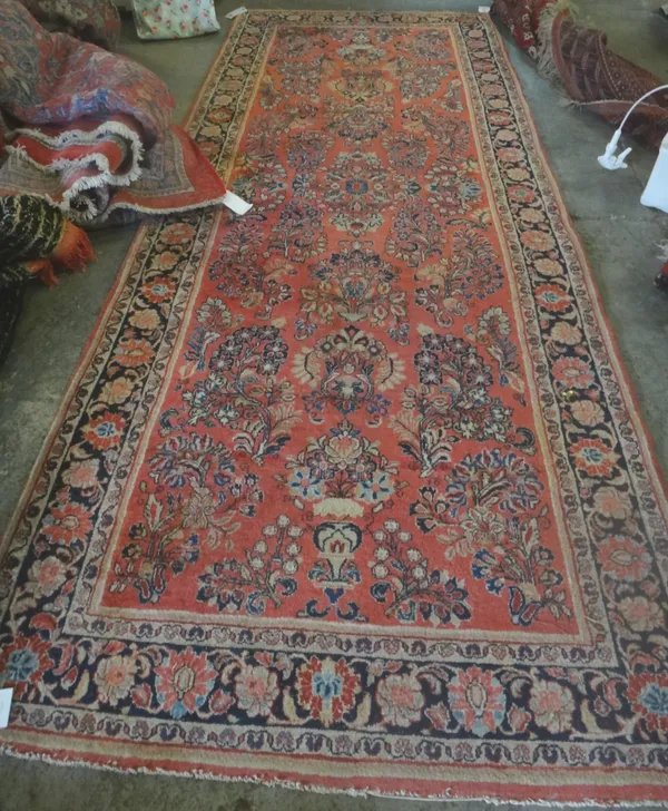 A Sarough Kelleh, Persian, the madder field with an allover design of floral sprays, a black palmette and trailing rose border, 350cm x 138cm.