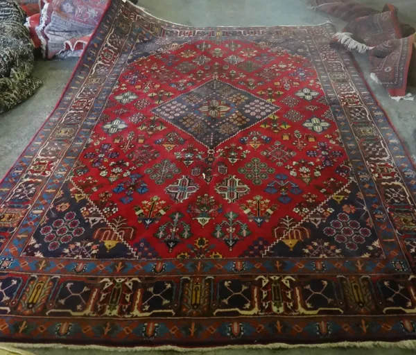 A Maymeh carpet, Persian, the madder field with an indigo diamond, with matching spandrels, floral diamond motifs, an indigo palmette and vine border,