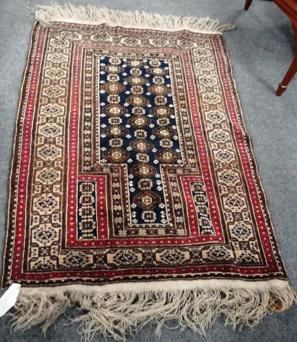 A Beluchistan prayer rug, with black flower mehrab and hooked medallion border, 136cm x 96cm.