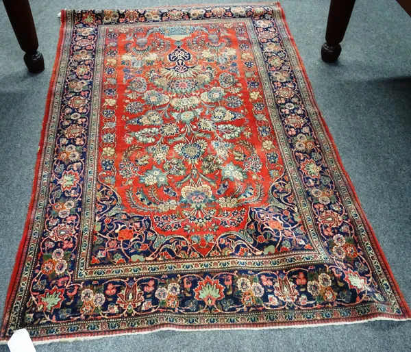 A Kashan rug, Persian, the madder field with a vase filled with abundant floral sprays, an indigo palmette, flower and vine border, 132cm x 210cm.
