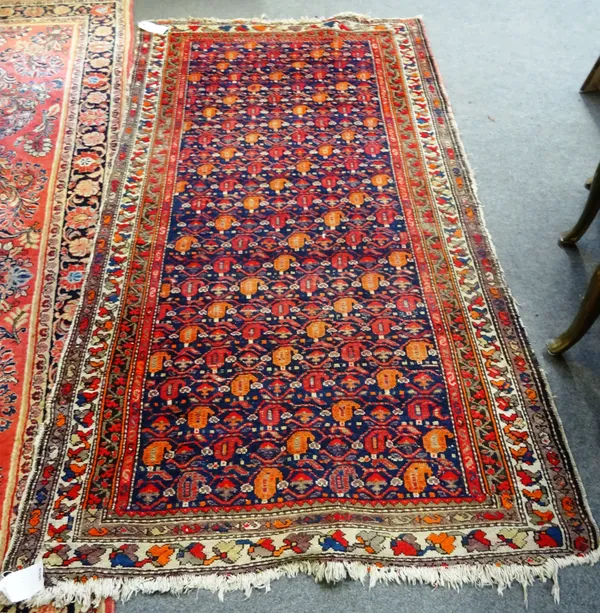 A Fereghan rug, Persian, the indigo field with an all over vine design with single boteh flowers, an ivory trailing leaf border, 240cm x 130cm.