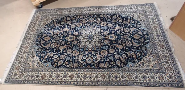 A modern Nain rug, with blue field, ivory medallion and ivory border, 176cm x 258cm.