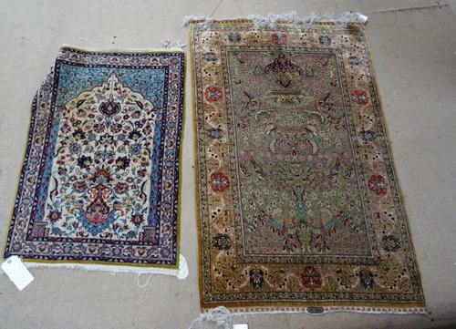 A Hereke silk rug, early 20th century, the pale green field with vase, flowers and birds, signed, 88cm x 134cm, together with an Isfahan prayer mat, w