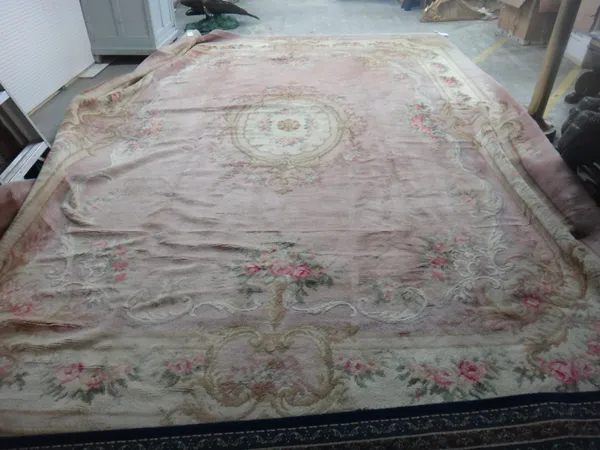 A large Austrian carpet, the plain pink field with an ivory roundel, floral spandrels, an ivory floral border, 488cm x 350cm.