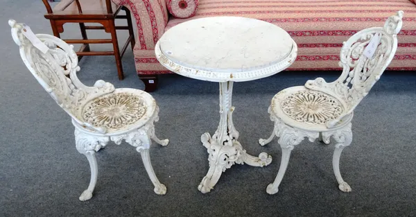 A pair of Victorian white painted cast iron garden chairs, 39cm wide, together with a similar circular table, 60cm wide x 70cm high.