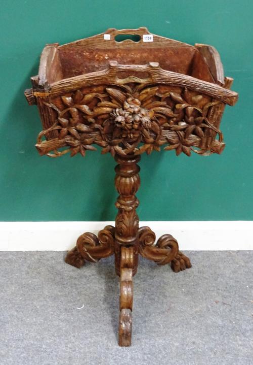 An early 20th century Black Forest carved oak jardiniere, on tripod base, 60cm wide x 99cm high.