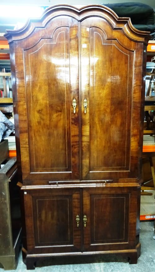 An 18th century Dutch inlaid mahogany floor standing corner cupboard, the bonnet top over two pairs of panel cupboards divided by brushing slide, on s