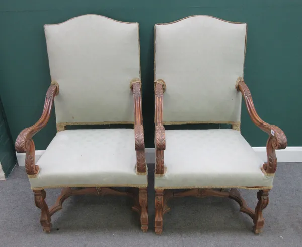 A pair of 17th century Italian style walnut framed open armchairs, on scroll supports united by shaped stretcher, each 65cm wide x 118cm high, (2).