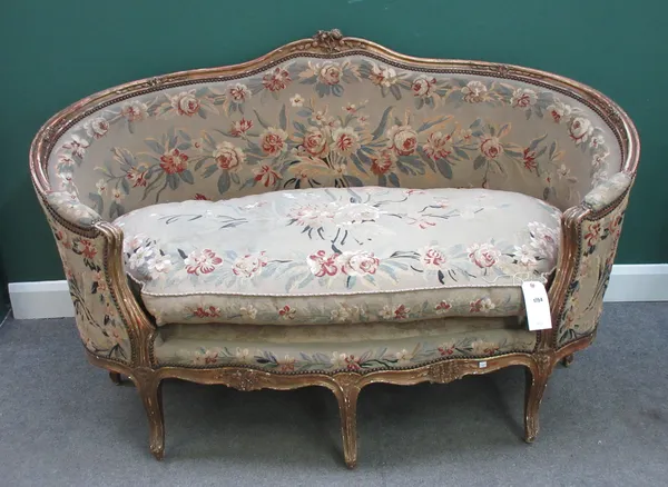 A Louis XV style gilt framed tub back sofa, on scroll supports, 162cm wide x 104cm high.