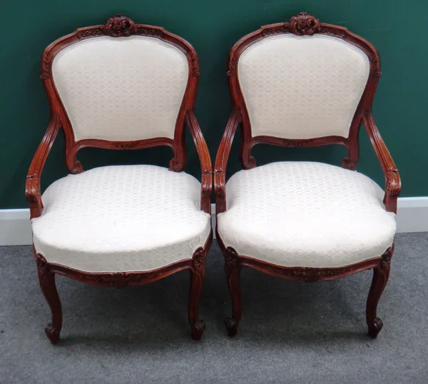 A pair of Louis XV style walnut framed open armchairs, each with bow seat and scroll supports, 55cm wide x 87cm high x 50cm deep. (2)