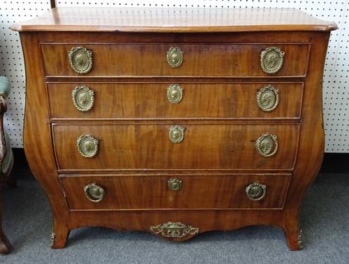 An 18th century German gilt metal mounted mahogany commode, the serpentine top over a bombe four drawer base, 100cm wide x 49cm deep x 83cm high.