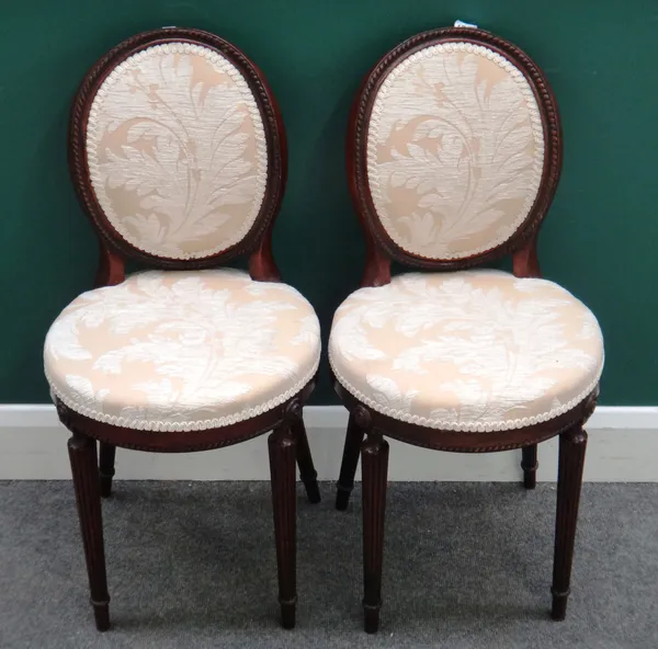 A pair of late 19th century mahogany framed oval back side chairs, on reeded supports, each 40cm wide x 81cm high x 42cm deep.