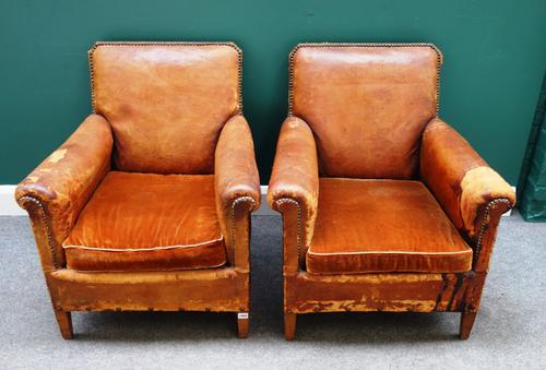 A pair of mid-20th century French brass studded brown leather upholstered easy armchairs, on tapered square supports, 73cm wide x 80cm high x 71cm dee