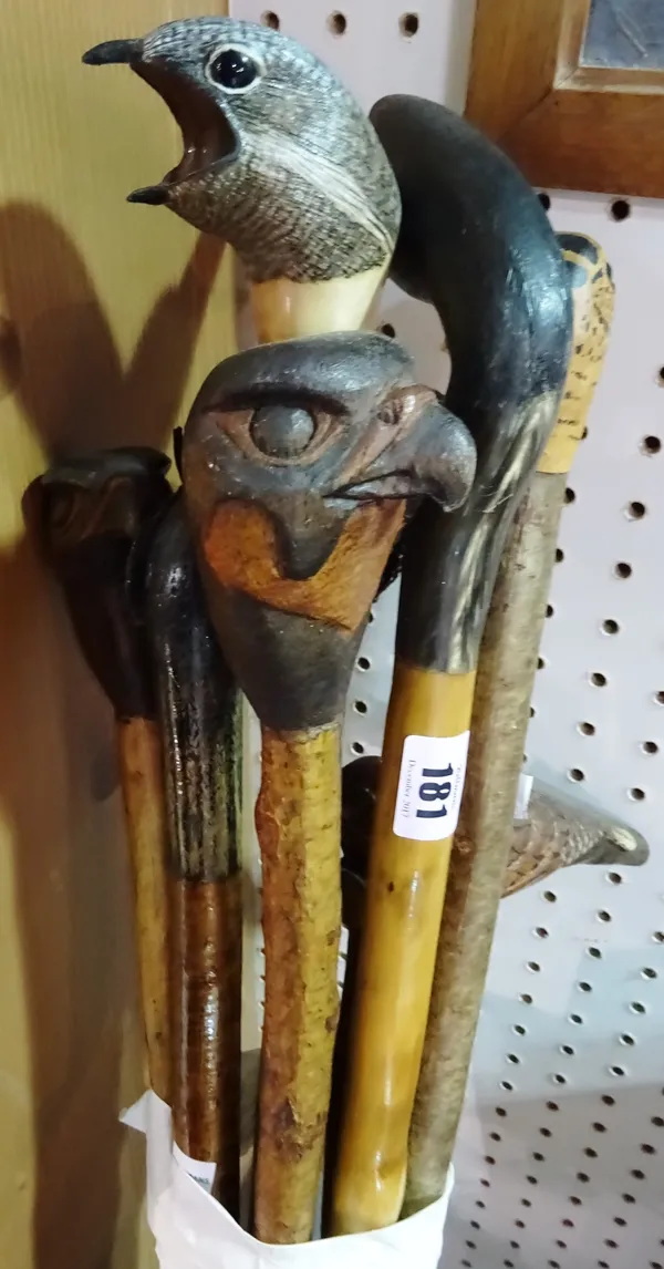Eight carved walking sticks, with bird head pommels, (8). CAB