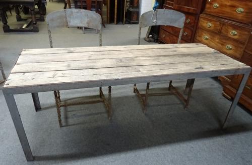 20th century Industrial Design; a metal bound rectangular plank top table, 73cm wide x 182cm long, together with four metal dining chairs with rivet d
