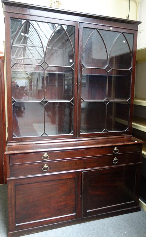 A George III mahogany bookcase cabinet, the pair of astragal glazed doors over two long drawers and pair of cupboards, on plinth base, 166cm wide x 24
