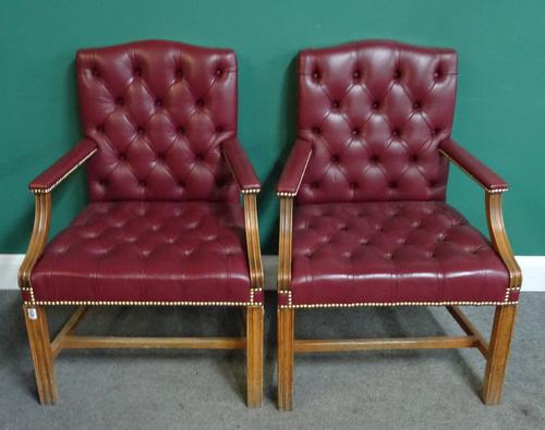 A pair of George III style brass studded rouge leather upholstered open armchairs, on channelled square supports, 68cm wide x 95cm high.
