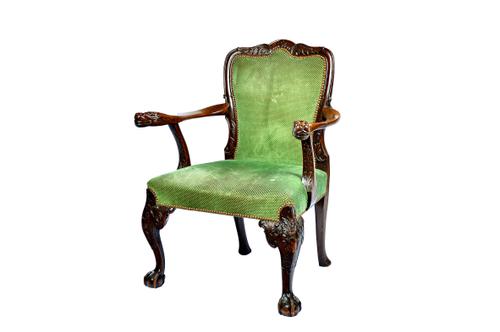 A George II style walnut framed open armchair, with lion's head finials, on ball and claw feet, 78cm wide x 99cm high.  Illustrated