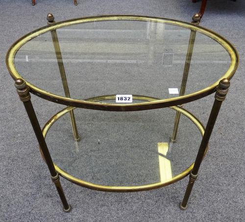 An early 20th century lacquered brass oval two tier etagere, on turned supports, 55cm wide x 52cm high x 39cm deep.
