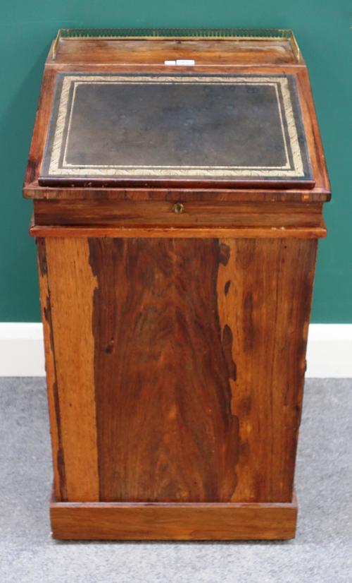 An early 19th century rosewood Davenport, the slide top with fitted interior, over four side drawers and dummy verso, 48cm wide x 87cm high x 53cm dee