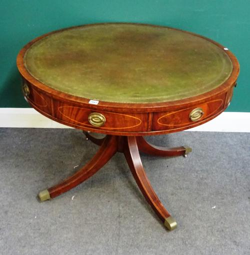 A George III style drum table, the gilt tooled circular leather inset top over four frieze drawers and four downswept supports, 102cm diameter, 74cm h