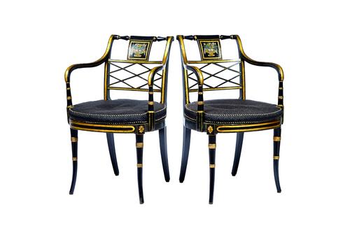 A pair of Regency ebonised parcel gilt floral painted lattice back open armchairs, with bow seats and splayed turned supports, 53cm wide x 84cm high.