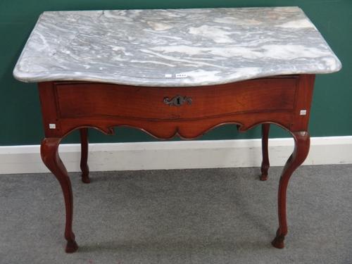 A Louis XV side table, the later grey marble serpentine top over a cherry single drawer base, on slender cabriole supports, 103cm wide x 62cm deep x 8