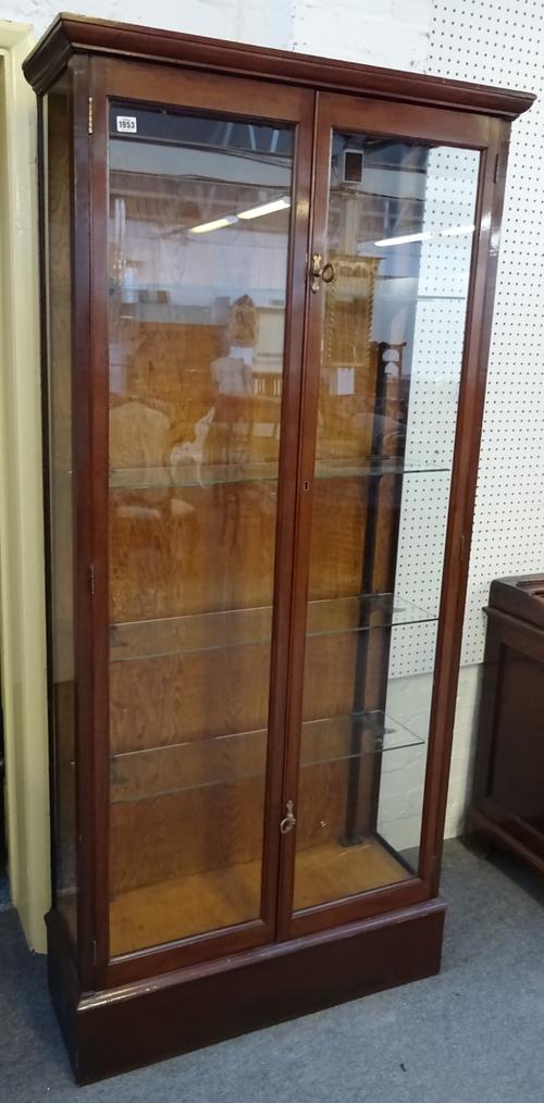 An early 20th century mahogany shop display cabinet with pair of glazed doors enclosing adjustable shelves, 91cm wide x 195cm high x 32cm deep.