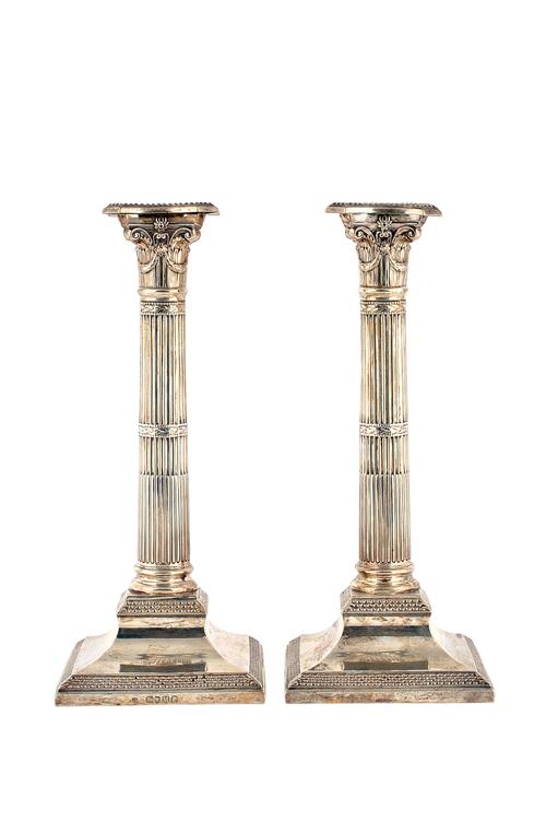 A pair of Victorian silver table candlesticks, each of classical column form, with fluted decoration, raised on a square base, (loaded), London 1887,
