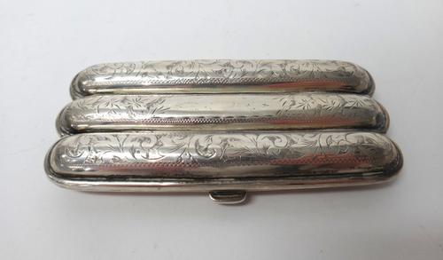 A silver shaped rectangular cigar case, gilt within, the exterior with foliate and scroll engraved decoration, Birmingham 1911, gross weight 72 gms.