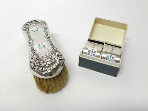 A pair of silver plain oval napkin rings, Sheffield 1917, combined weight 120 gms, with a box and a silver mounted clothes brush, with floral embossed