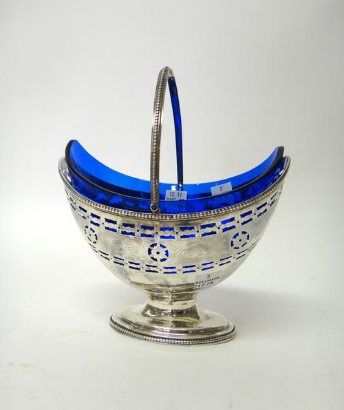 A George III silver sugar basket, of oval form, with pierced and engraved decoration, within a beaded rim, with a swingover handle and raised on an ov