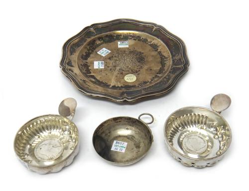 A European silver tasse de vin, the base inset with a hispanic coin, with fluted decoration and loop handle, and two further examples, and a European