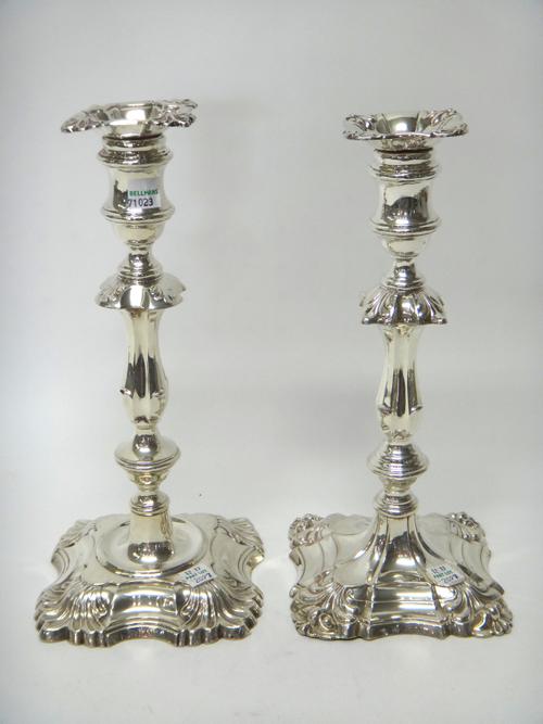 Two late Victorian silver loaded table candlesticks, each in a differing late 18th century design, raised on a square base, London 1895 and 1900, (2).