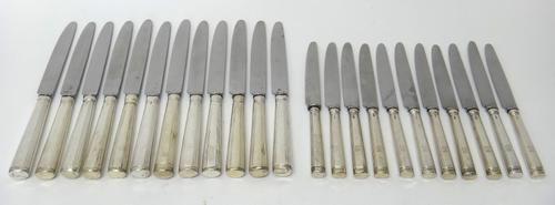 Twelve table knives, having loaded silver handles and with later replacement steel blades, the marks mostly rubbed and eleven cheese knives, having lo