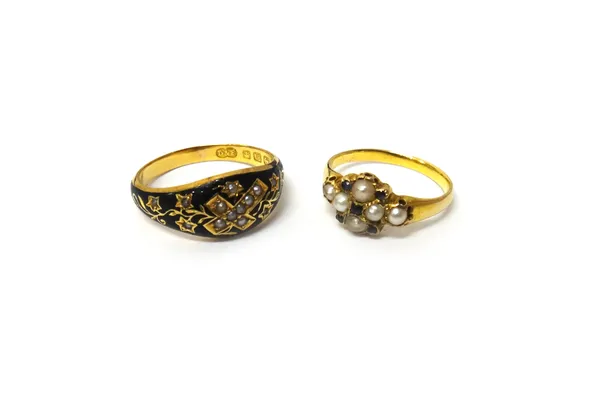 A Victorian 18ct gold, black enamelled and seed pearl set mourning ring, with a central cross and foliate spray motifs, glazed with a locket to the un