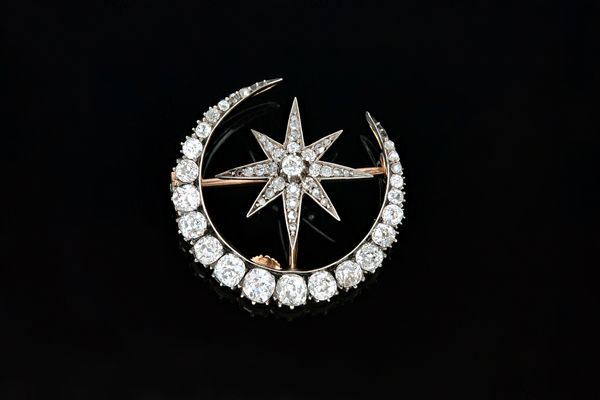 A Victorian diamond brooch, designed as a crescent enclosing an eight pointed star, mounted with cushion shaped and rose cut diamonds and with a twin