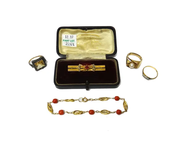 A gold and red gem set bar brooch, detailed 9 CT, with a case, a gold bracelet, spaced with coral beads at intervals, on a boltring clasp, a gold and