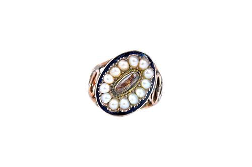 A gold, half pearl set and black enamelled mourning ring, glazed with an oval hair locket compartment at the centre, in a surround of half pearls, wit