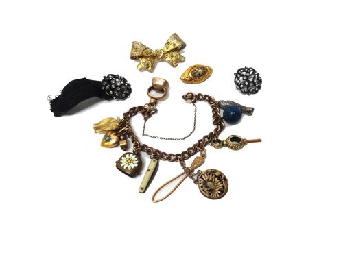 A gilt metal curb link bracelet, fitted with eleven pendants and charms, including a fob seal, a 15ct gold and turquoise set heart, a watch key and a