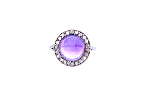 A cabochon amethyst and rose diamond set ring, mounted with the cabochon amethyst at the centre, in a surround of rose cut diamonds between split shou