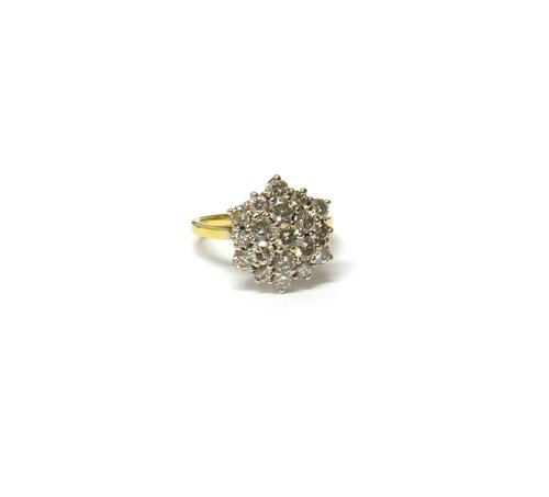 A gold and diamond set nineteen stone hexagonal cluster ring, claw set with circular cut diamonds, detailed 18ct, ring size M, with a case.