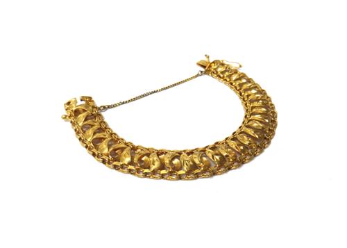 A gold bracelet, pierced in a multiple link design, with engraved decoration, on a snap clasp, fitted with a safety chain, weight 24.5 gms.