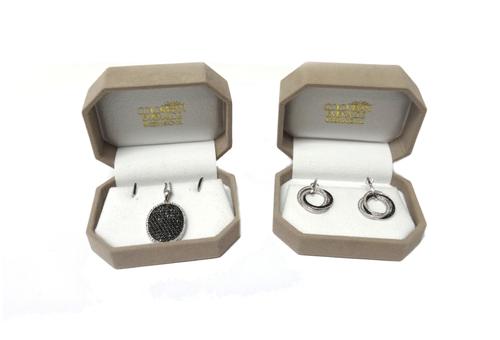 A white gold, black diamond and diamond set oval pendant, pave set with circular cut black diamonds to the centre, within a surround of small circular