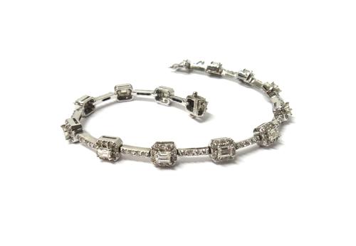 An 18ct white gold and diamond bracelet, formed as a series of cut cornered square clusters, each centred by an emerald cut diamond, in a surround of