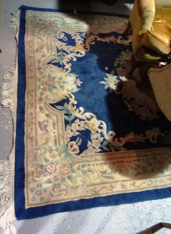 A group of three Chinese carpets with dark blue ground and central medallion, the largest 214cm wide x 308cm long, 120cm x 200cm and 145cm x 71cm. (3)