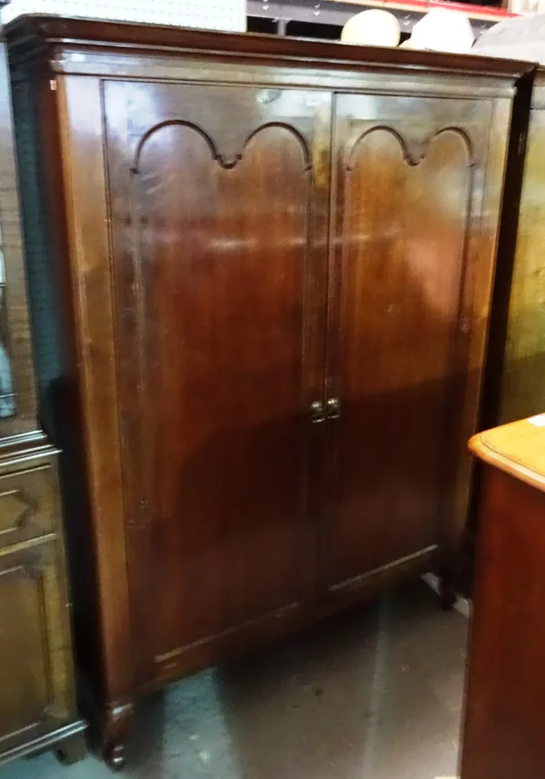 An early 20th century mahogany two door wardrobe on scroll supports, 125cm wide x 174cm high. M10