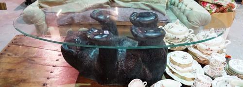 A 20th century fibreglass coffee table modelled as a bear, with an oval glass top, 122cm wide x 40cm high.  D5