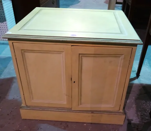 A 20th century green painted two door cupboard, 63cm wide x 55cm high. D7