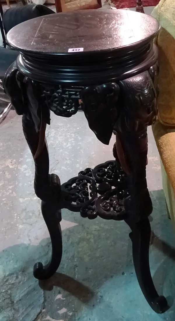 An ebonised hardwood circular jardiniere stand with carved elephant legs, 40cm wide. F6